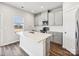 Modern kitchen boasts white cabinets, stainless steel appliances, and a center island with a sink at 1411 Windy Park Dr, Stanley, NC 28164