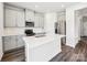 Bright, open kitchen features stainless steel appliances, a white countertop island, and gray flooring at 1411 Windy Park Dr, Stanley, NC 28164