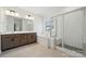 An elegant bathroom featuring a double vanity, a soaking tub, and a separate glass-enclosed shower at 15238 Ravenall Dr, Huntersville, NC 28078