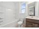Bright bathroom featuring a white bathtub and shower with a wooden vanity and natural light at 15238 Ravenall Dr, Huntersville, NC 28078