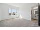 Bright, neutral bedroom featuring a view of the ensuite bathroom and three large windows at 15238 Ravenall Dr, Huntersville, NC 28078