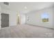 Spacious bedroom with large windows, neutral carpeting, and a glimpse of the bathroom at 15238 Ravenall Dr, Huntersville, NC 28078