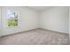 Bright bedroom with neutral carpet and a window view of the outside greenery and sunlight at 15238 Ravenall Dr, Huntersville, NC 28078