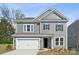 Charming two-story home with gray siding, a two-car garage, and a well-maintained front yard at 15238 Ravenall Dr, Huntersville, NC 28078