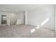 Spacious living room filled with natural light and neutral carpeting leading to the stairway at 15238 Ravenall Dr, Huntersville, NC 28078