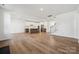 Open-concept living space with hardwood floors, a modern staircase, and access to the kitchen at 15238 Ravenall Dr, Huntersville, NC 28078