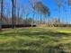 Large, grassy backyard is surrounded by a wooden fence and mature trees for privacy at 1934 Hollybrook Ln, Lancaster, SC 29720