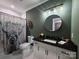 Eclectic bathroom with black granite countertops, unique shower curtain, and round mirror at 1934 Hollybrook Ln, Lancaster, SC 29720
