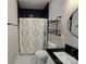 Modern bathroom with black and white accents, including a patterned shower curtain and tiled floor at 1934 Hollybrook Ln, Lancaster, SC 29720