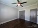 Bedroom features neutral walls, ceiling fan, dark floors, and closet for ample storage at 1934 Hollybrook Ln, Lancaster, SC 29720