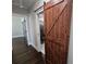 Hallway with hardwood floors, open barn door, and view into the bathroom at 1934 Hollybrook Ln, Lancaster, SC 29720