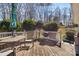 Back deck with weathered wooden boards, a table, chair, and a grill for outdoor cooking at 211 Kingsway Cir, Charlotte, NC 28214
