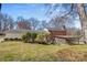 A home backyard featuring a deck, screened in porch and mature trees at 211 Kingsway Cir, Charlotte, NC 28214