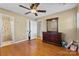 Bedroom with hardwood floors, ceiling fan, dresser with mirror, closet, and access to the bathroom at 211 Kingsway Cir, Charlotte, NC 28214
