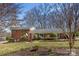 Charming brick home featuring mature landscaping and a well-manicured front lawn at 211 Kingsway Cir, Charlotte, NC 28214