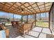 Relaxing screened porch with ceiling fan, wicker furniture, and views of the wooded backyard at 211 Kingsway Cir, Charlotte, NC 28214