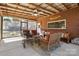 Outdoor seating area in a screened porch with comfortable furniture, a ceiling fan, and brick wall at 211 Kingsway Cir, Charlotte, NC 28214