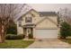 Traditional two-story house with a two-car garage, stone entryway, and manicured landscaping at 2111 Bennett Woods Ct, Charlotte, NC 28216