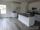 Open kitchen featuring a large kitchen island, granite countertops and white cabinets at 212 Sugar Hill Rd, Troutman, NC 28166