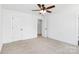 Bedroom showcasing neutral carpet, white walls, modern ceiling fan, and two closets at 230 Georgia Sw St, Concord, NC 28025