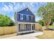 Charming blue two-story home with newly installed light wood fence, manicured lawn, and inviting front porch at 230 Georgia Sw St, Concord, NC 28025