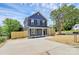 Inviting blue two-story home featuring a new fence, driveway, and sidewalk, providing a welcoming curb appeal at 230 Georgia Sw St, Concord, NC 28025