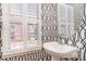 A powder room with pedestal sink, designer wallpaper, and plantation shutters at 243 Lincoln St, Charlotte, NC 28203