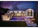 Beautiful backyard featuring an illuminated pool, stone patio, and inviting fire pit area at 2536 Brawley School Rd, Mooresville, NC 28117
