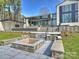 Expansive backyard featuring tiered landscaping, a built-in fire pit, and manicured lawn at 2536 Brawley School Rd, Mooresville, NC 28117