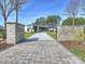 Long driveway lined with stone walls leading to a modern home with large windows and lush landscaping at 2536 Brawley School Rd, Mooresville, NC 28117