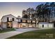 Stunning modern home with clean lines, large windows, and a stone facade offers sophisticated curb appeal at 2536 Brawley School Rd, Mooresville, NC 28117