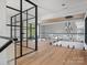 Bright hallway features hardwood floors, glass railings, clerestory windows, and a stylish black metal framed glass divider at 2536 Brawley School Rd, Mooresville, NC 28117
