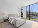 Lake view main bedroom with a bench, luxurious bedding, and abundant natural light at 2536 Brawley School Rd, Mooresville, NC 28117