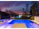 Backyard view of a pool and lake at sunset with a covered seating area and lounge chairs at 2536 Brawley School Rd, Mooresville, NC 28117