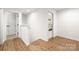 Hallway with wood flooring, white walls and trim, with view to staircase and door to bedroom at 3117 Williams Rd, Matthews, NC 28105