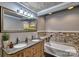 Bathroom featuring a double sink vanity, stone accents, and a luxurious bathtub, perfect for relaxation at 415 E Richland St, Kershaw, SC 29067