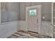 Bright entryway with wainscoting, stylish floors, and a glass-paneled front door at 415 E Richland St, Kershaw, SC 29067