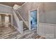 Inviting foyer featuring wood-look floors, staircase, and doorway into another room with a fireplace at 415 E Richland St, Kershaw, SC 29067