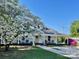 Inviting home with a covered porch, a walkway, and a mature dogwood tree in full bloom at 415 E Richland St, Kershaw, SC 29067