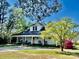Charming white home with a full front porch, rocking chairs, and mature trees at 415 E Richland St, Kershaw, SC 29067
