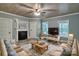 Inviting living room featuring wood-look floors, fireplace, comfortable sofas, and natural light from the windows at 415 E Richland St, Kershaw, SC 29067