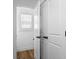 Hallway with white doors, wood-look flooring, modern black door hardware, and natural light at 425 Messner St, Salisbury, NC 28144