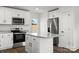 Well-lit kitchen featuring stainless steel appliances, granite countertops, white cabinets, and modern island at 425 Messner St, Salisbury, NC 28144