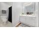 Bright bathroom featuring a white vanity with gold hardware, and a shower with a dark curtain at 4507 Antelope Ln, Charlotte, NC 28269