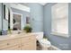 Cozy bathroom with soft blue walls, a neutral vanity, and good natural lighting from the window at 4507 Antelope Ln, Charlotte, NC 28269