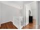 Upstairs hallway featuring hardwood floors, a sputnik light fixture, and painted white trim at 4507 Antelope Ln, Charlotte, NC 28269