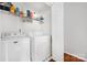 Laundry room with white washer, dryer, overhead rack with detergent, and a white door at 4507 Antelope Ln, Charlotte, NC 28269