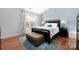 Bright main bedroom has a large window, ceiling fan, accent wall, and an area rug on hardwood floor at 4507 Antelope Ln, Charlotte, NC 28269