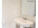This half bathroom features a pedestal sink, decorative mirror, and modern fixtures, offering convenience and style for guests at 4625 Potters Wheel Dr, Fort Mill, SC 29715