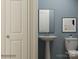 Modern powder room featuring a pedestal sink, sleek mirror, and stylish decor at 4633 Potters Wheel Dr, Fort Mill, SC 29715